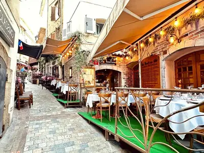 a restaurant with tables and chairs on a street at Place du Suquet - Terrasse - 3 Chambres - Parking in Cannes
