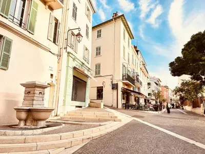 a city street with buildings and a fountain on the street at Place du Suquet - Terrasse - 3 Chambres - Parking in Cannes