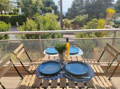 a table with two blue plates on a balcony at Appartement, 2 pièces ,résidence avec piscine in Cannes