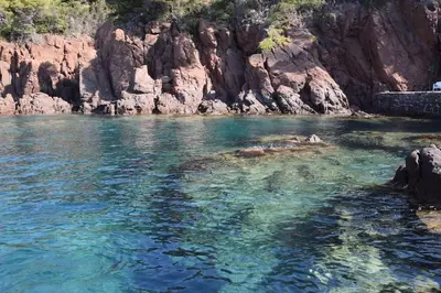 a body of water next to a rocky cliff at Appartement, 2 pièces ,résidence avec piscine in Cannes
