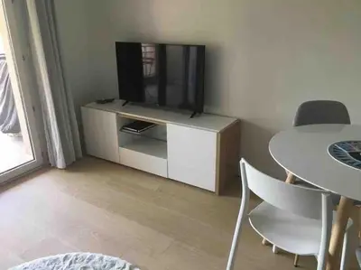 a living room with a tv and a table with chairs at Appartement, 2 pièces ,résidence avec piscine in Cannes