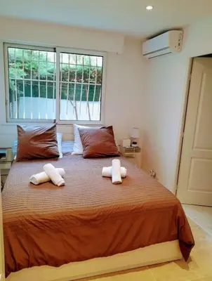 a bedroom with a large bed with two towels on it at Appartement 2 pièces dans résidence avec piscine Isola Bella in Cannes