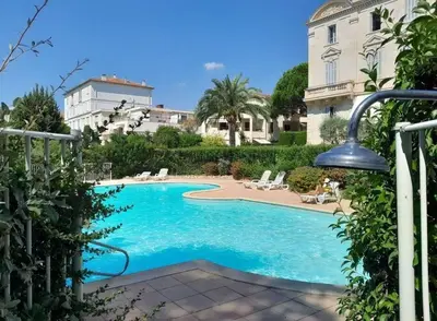 a swimming pool in front of a building at Appartement 2 pièces dans résidence avec piscine Isola Bella in Cannes