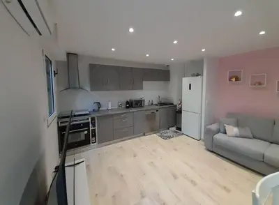 a living room with a couch and a kitchen at Appartement 2 pièces dans résidence avec piscine Isola Bella in Cannes