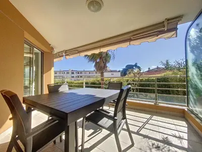 a dining room table with chairs and a large window at Cannes - Basse Californie - 3 pièces in Cannes