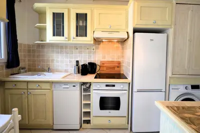 a kitchen with yellow cabinets and a white refrigerator at 