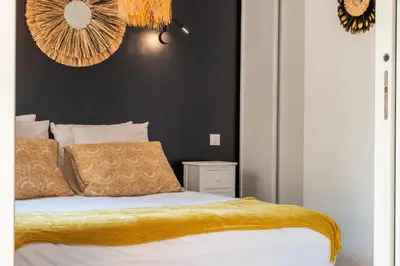 a bedroom with a bed with a yellow blanket on it at Cozy 1-Br Apartment heart of Palm Beach district in Cannes