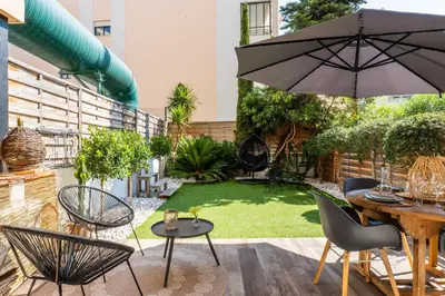 a patio with a table and chairs and an umbrella at Cozy 1-Br Apartment heart of Palm Beach district in Cannes