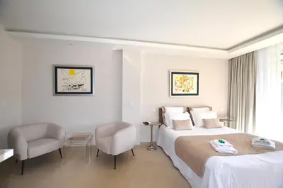 a hotel room with a bed and two chairs at Studio Cannes Grand Hôtel Cormoran avec Terrrasse in Cannes