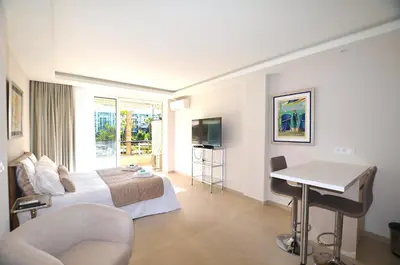 a hotel room with a bed and a table and a desk at Studio Cannes Grand Hôtel Cormoran avec Terrrasse in Cannes