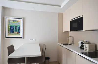 a small kitchen with a white counter top and a table at Studio Cannes Grand Hôtel Cormoran avec Terrrasse in Cannes