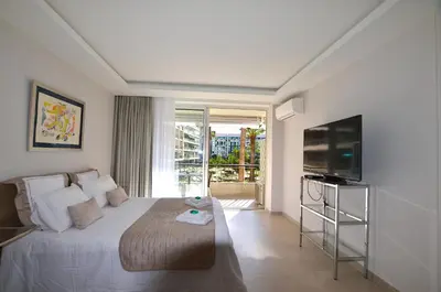 a bedroom with a large bed and a television at Studio Cannes Grand Hôtel Cormoran avec Terrrasse in Cannes