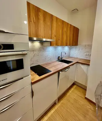 a kitchen with white appliances and wooden cabinets at Splendid 1 bedroom and 1 sofabed renovated 2P3 by RIVAEVENT in Cannes