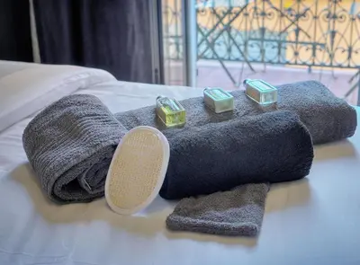 a pile of towels and candles on a bed at Superb 2 Bedrooms, 1 sofabed 3P1 by RIVAEVENT in Cannes