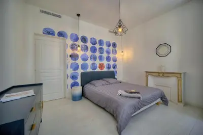 a bedroom with a bed with blue plates on the wall at Superb 2 Bedrooms, 1 sofabed 3P1 by RIVAEVENT in Cannes