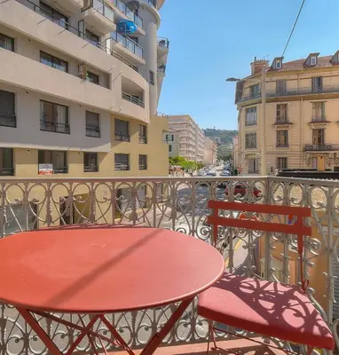 a red table and two chairs on a balcony at Superb 2 Bedrooms, 1 sofabed 3P1 by RIVAEVENT in Cannes