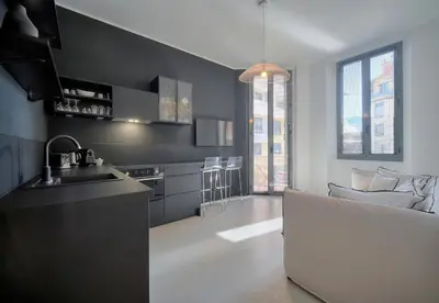 a kitchen with black walls and a couch in a room at Superb 2 Bedrooms, 1 sofabed 3P1 by RIVAEVENT in Cannes