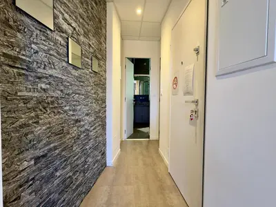 a hallway with a stone wall and a door at Eleganza By SCLS Locations in Cannes