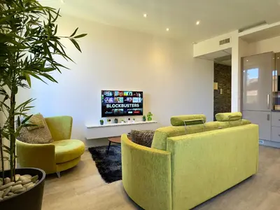 a living room with two chairs and a tv at Eleganza By SCLS Locations in Cannes