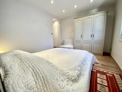 a bedroom with a large white bed and a closet at HENRY IV 2 pieces MES1112 in Cannes