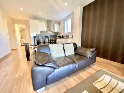a living room with a leather couch and a kitchen at HENRY IV 2 pieces MES1112 in Cannes