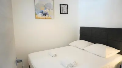 a bed with two pillows and a picture on the wall at Centre Cannes, Le Grand Turkheim By Palmazur Vacances in Cannes