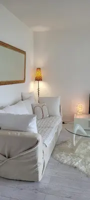 a white bedroom with a bed and a table at Cannes centre beau 2 pièces 50 M2 plus terrasse à 12 min plages et Palais au calme in Cannes