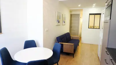 a room with a table and chairs and a white table and chairs at Proche Carlton & Croisette, Appartement 302 - Palmazur Vacances in Cannes