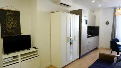 a living room with a television and a kitchen at Proche Carlton & Croisette, Appartement 302 - Palmazur Vacances in Cannes