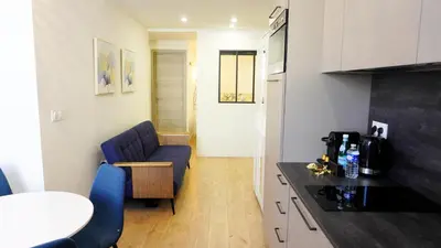 a small kitchen with a blue couch and a table at Proche Carlton & Croisette, Appartement 302 - Palmazur Vacances in Cannes