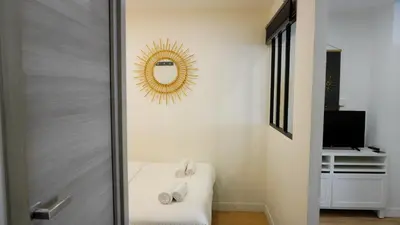 a room with a mirror and a bed and a television at Proche Carlton & Croisette, Appartement 302 - Palmazur Vacances in Cannes