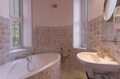 a bathroom with a tub and a sink at Le Château Vallombrosa by Halldis in Cannes