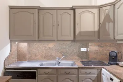 a kitchen with white cabinets and a sink at Le Château Vallombrosa by Halldis in Cannes
