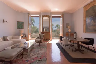 a living room with a couch and a table and chairs at Le Château Vallombrosa by Halldis in Cannes