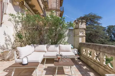 a white couch sitting on a patio at Le Château Vallombrosa by Halldis in Cannes