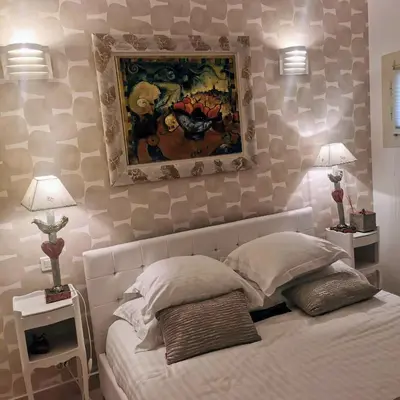 a bedroom with a bed with a painting on the wall at Blue Dream Cannes Guest House in Cannes