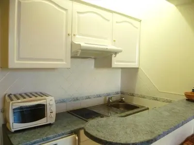 a kitchen with white cabinets and a microwave at Studio Croisette in Cannes