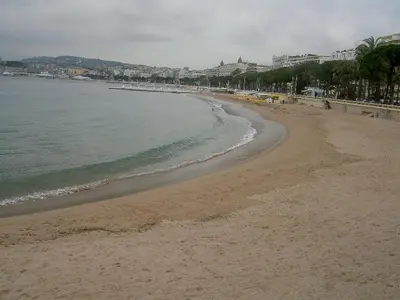 a sandy beach with the ocean and buildings in the background at Studio Croisette in Cannes