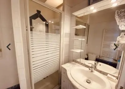 a white bathroom with a sink and a mirror at Studio Croisette in Cannes
