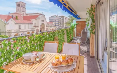 a table with food and drinks on a balcony at Le Concorde - Charmant appt avec terrasse in Cannes