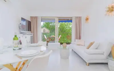a white living room with a white couch and a table at Le Concorde - Charmant appt avec terrasse in Cannes