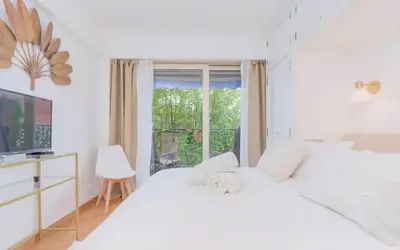 a bedroom with two white beds and a window at Le Concorde - Charmant appt avec terrasse in Cannes