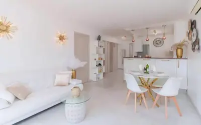 a white living room with a couch and a table at Le Concorde - Charmant appt avec terrasse in Cannes