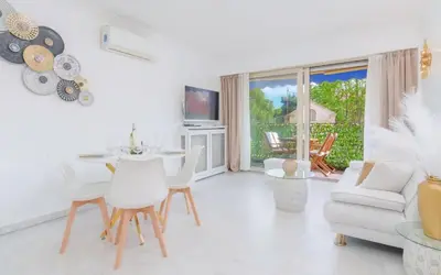 a white living room with a table and chairs at Le Concorde - Charmant appt avec terrasse in Cannes