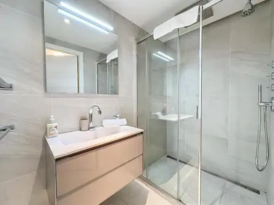 a bathroom with a sink and a glass shower at PLEIN SUD - le tapis rouge Croisette in Cannes
