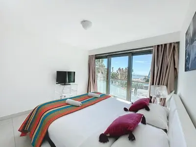 a bedroom with a large bed with pillows and a window at PLEIN SUD - le tapis rouge Croisette in Cannes