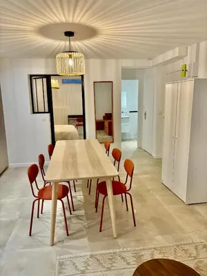 a dining room with a table and red chairs at Villa CANA in Cannes