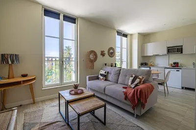 a living room with a couch and a kitchen at Quiet and luxurious studio - Cannes Center in Cannes