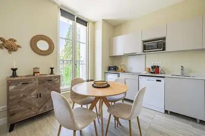 a kitchen with a table and chairs in a room at Quiet and luxurious studio - Cannes Center in Cannes