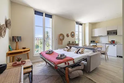 a bedroom with a large bed and a kitchen at Quiet and luxurious studio - Cannes Center in Cannes